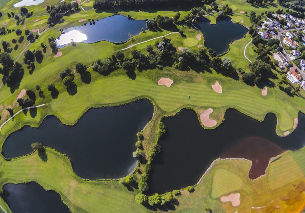 Golfplatz aus der Luft mit Wasserhindernissen neben den Spielbahnen.